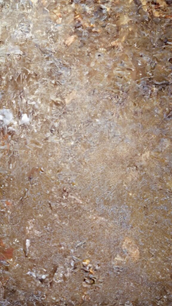 Modern kitchen scene with naan pizza preparation; features sautéed vegetables, mozzarella cheese and whisked eggs on a marble countertop